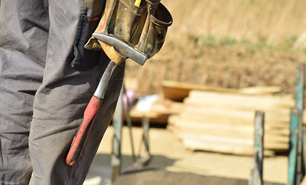 Image of worker on construction site, close-up on tool bag