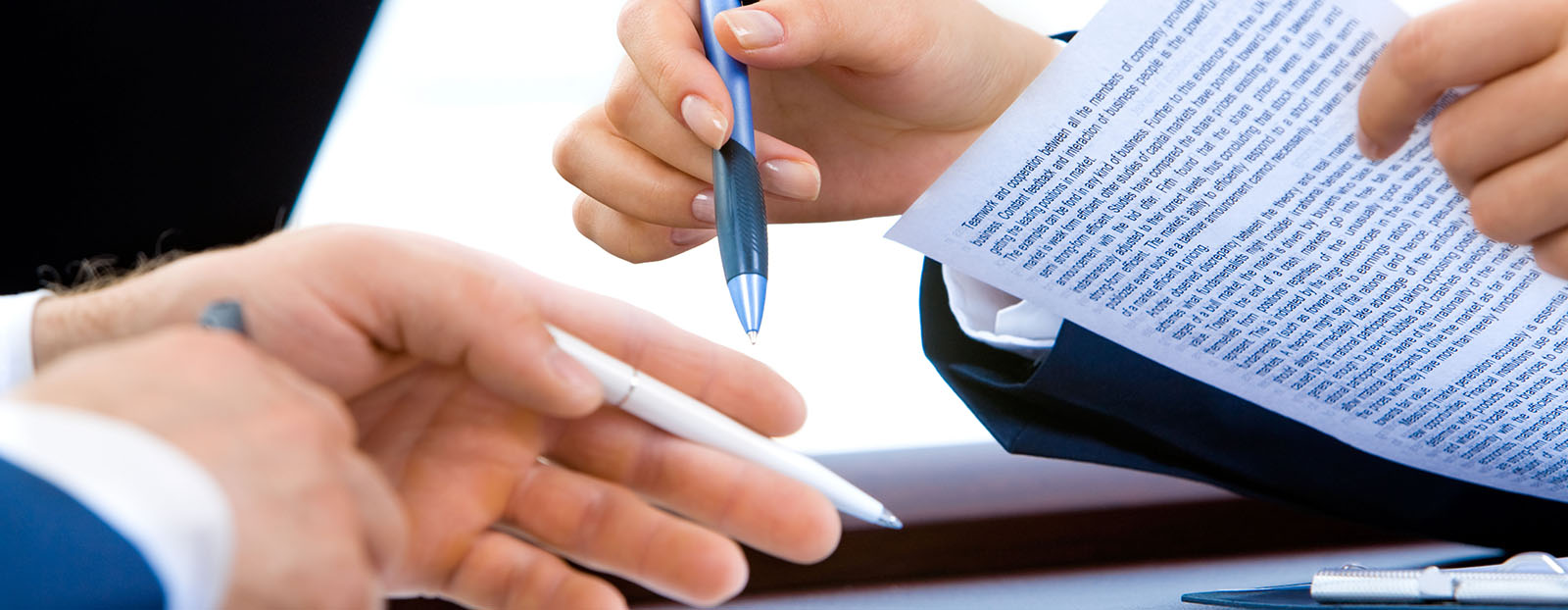 Image of meeting, closeup on hands holding pens and notebooks