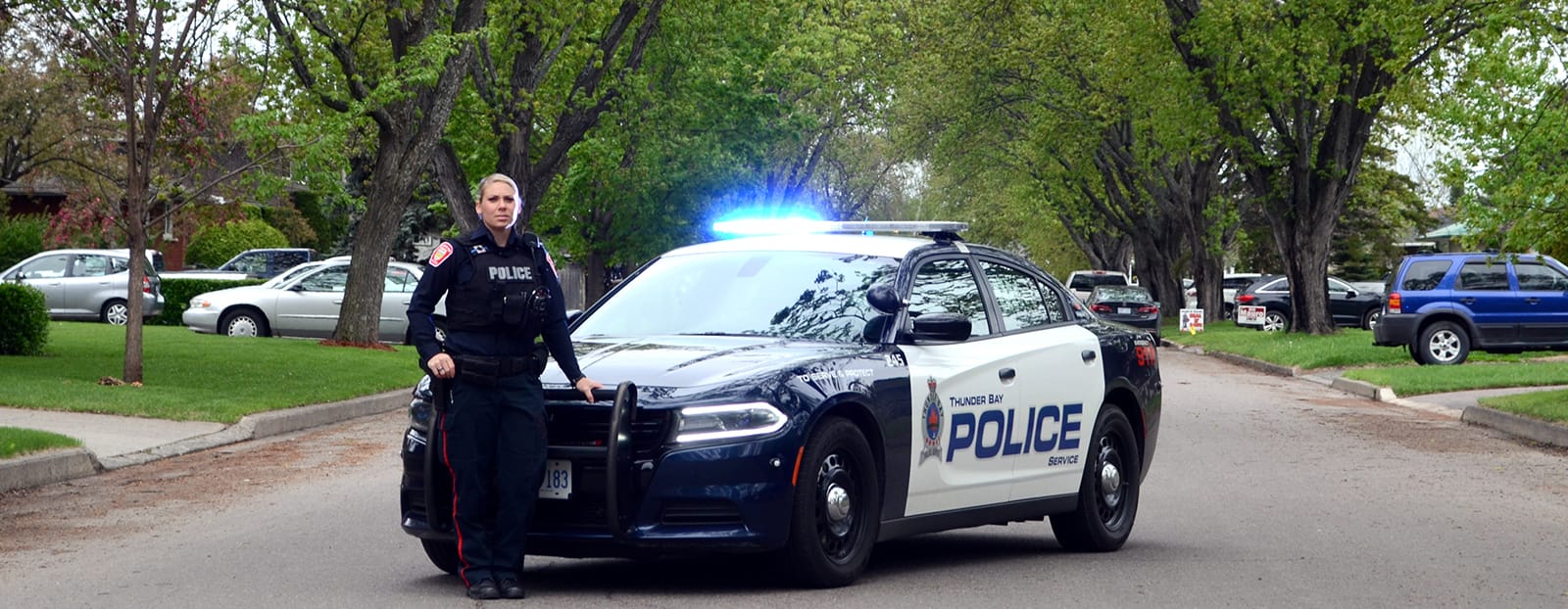 police car with police officer standing in front