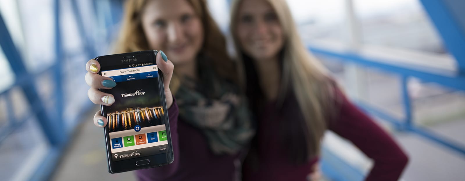 woman holding cell phone with ping street app open