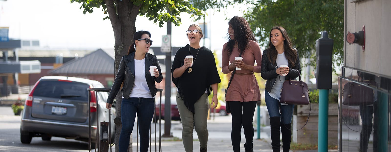 women laghing walking down sidewalk