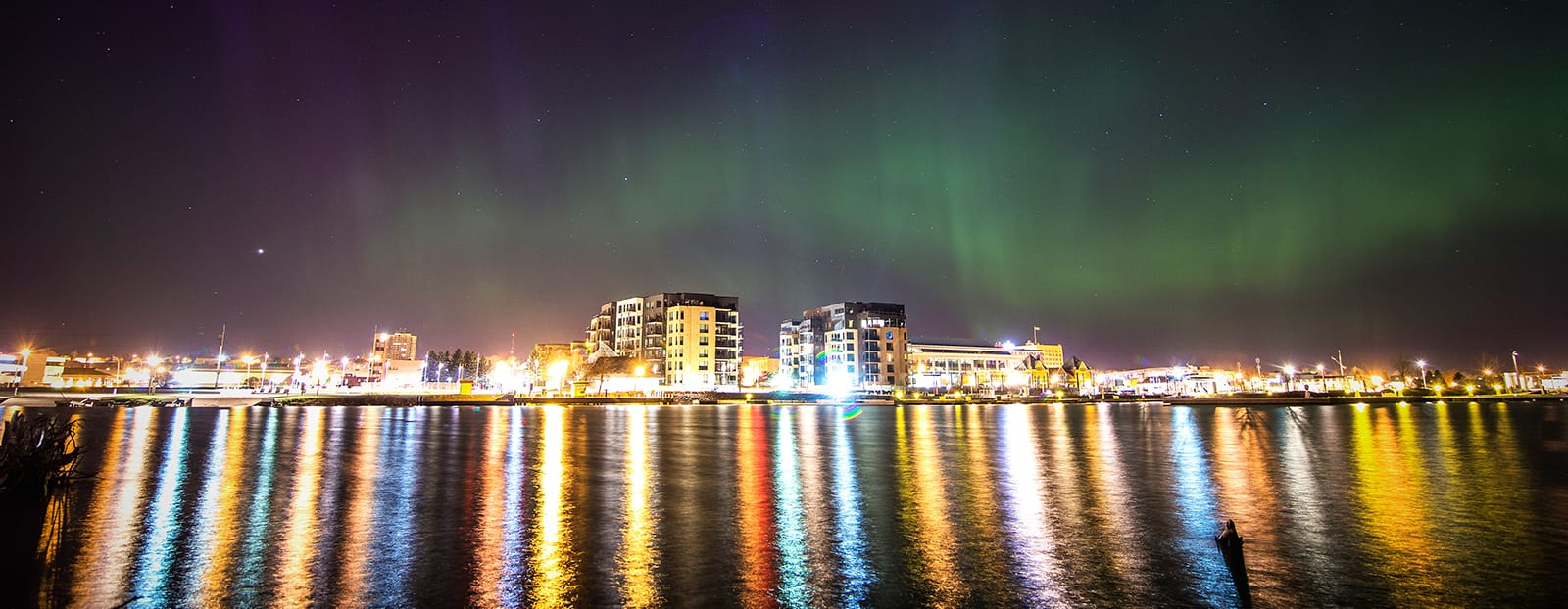 Northern Lights over city waterfront