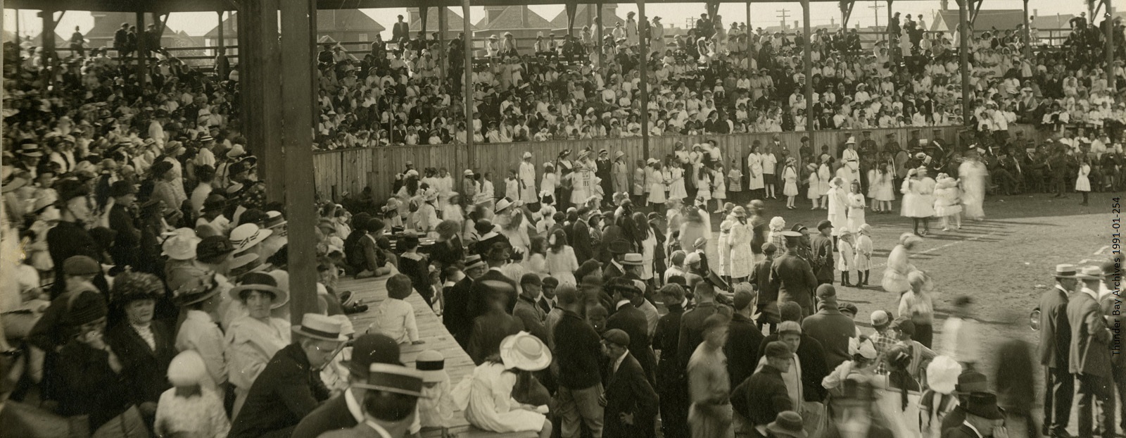 black and white photo of 1910s crowd in stadium stands