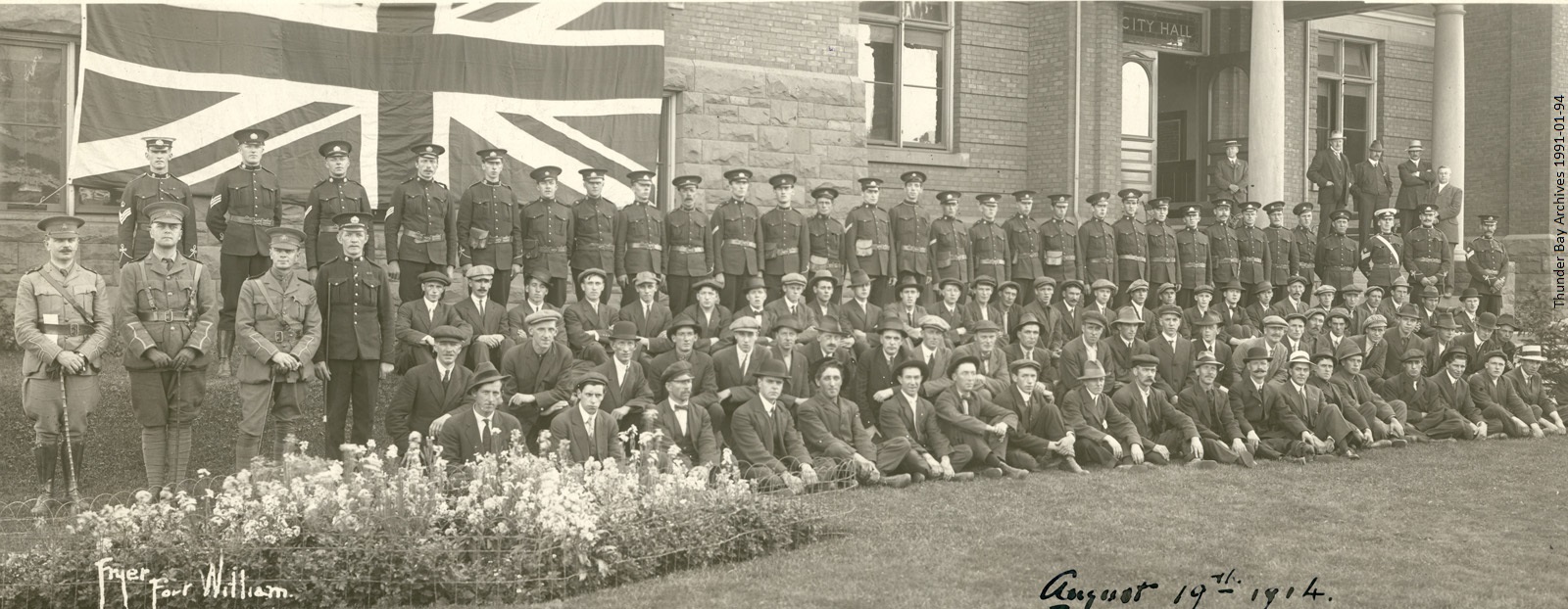 group portrait of WWI soldiers in front of Union Jack flag