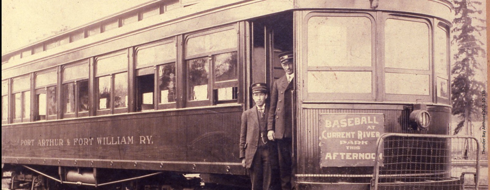 Two men standing in the doorway of a trolley car 