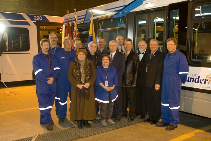 A group of people posing in front of a new accesible bus