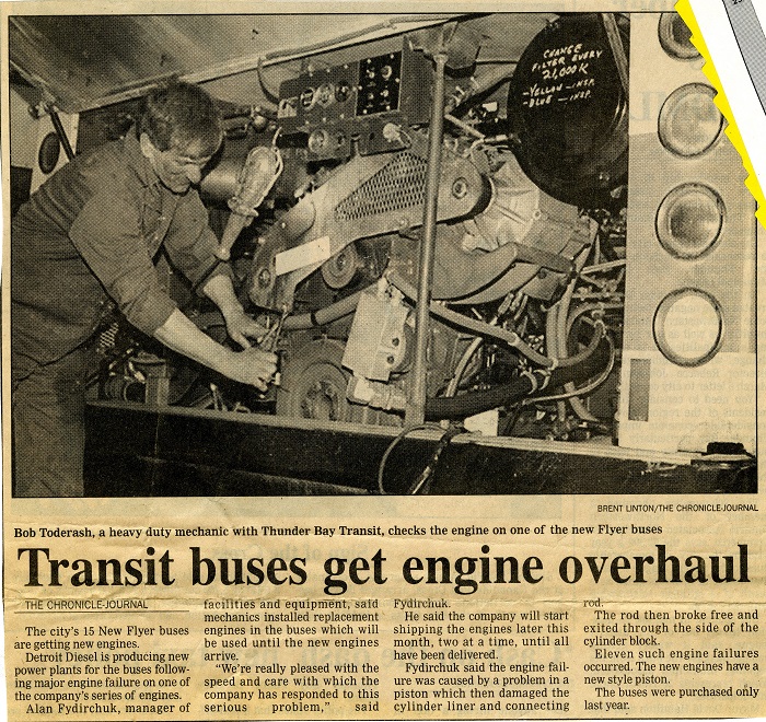 A newspaper clipping with a photo of a man working on an engine