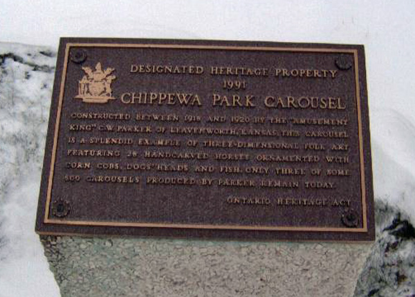 A metal plaque is pictured mounted on a stone outside in winter