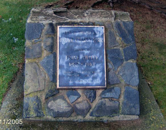a coloured photo showing a rock fixture in the grass with a plaque affixed 