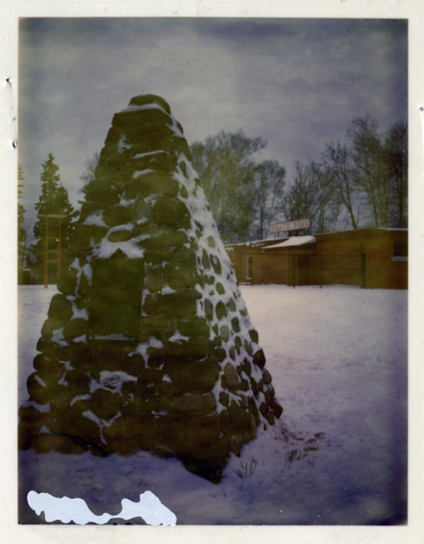 a pile or rocks in an empty field of grass