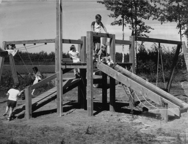 Children playing on a play structure in a green space