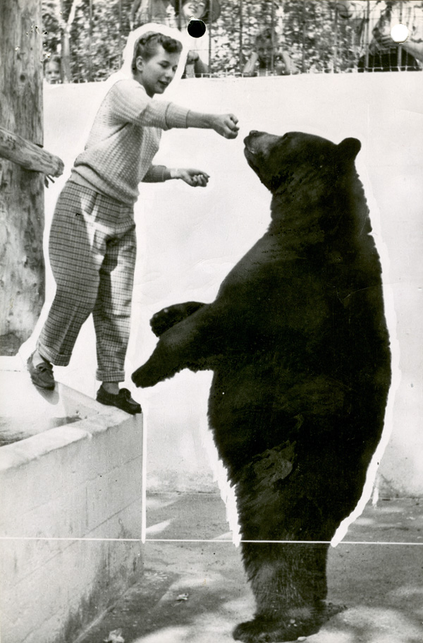 A young child playing with a bear in a black and white photo 