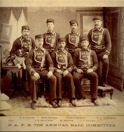 A group of firefighters and a dog sitting together in uniform