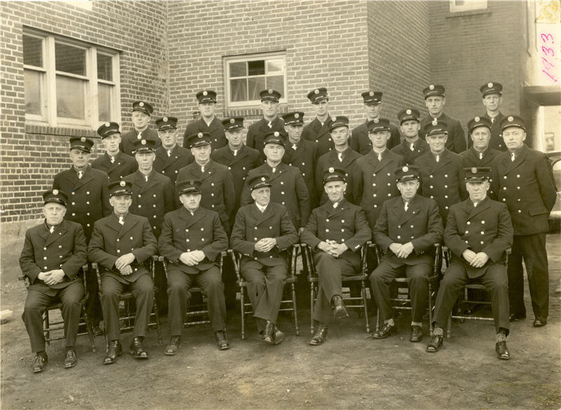 A group of firefighters sitting together in uniform 