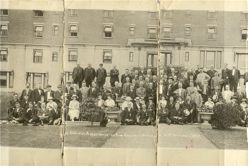 A photo that has been torn and taped together of a group of men and women