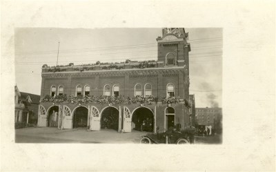 A photgraph of a brick building with people out front