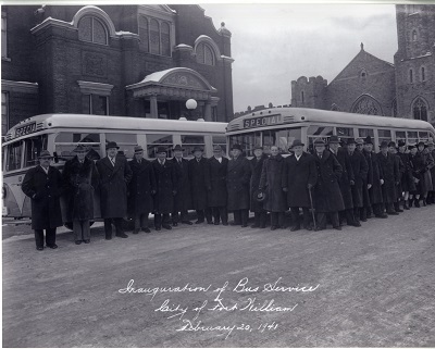 Conductors and workers standing in front of newly built gas buses