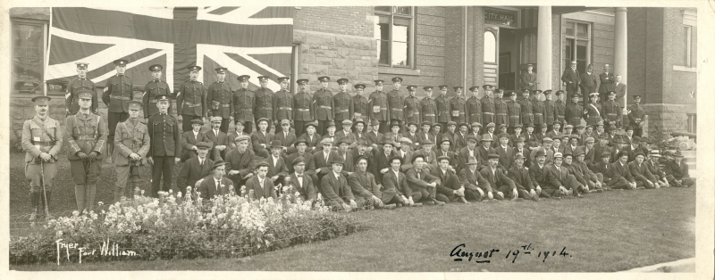 A group of soldiers standing in front of a British Union Jack Flag