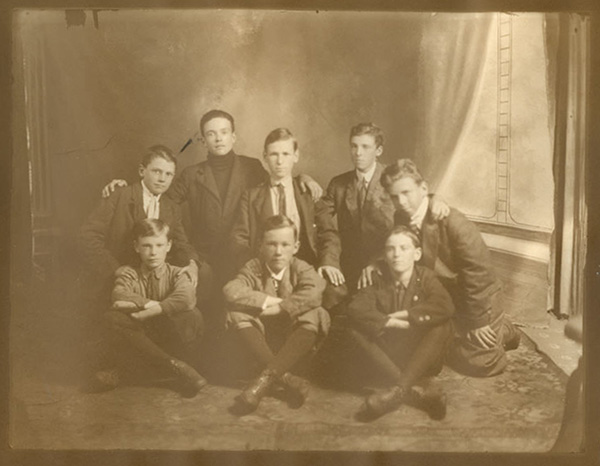 Eight boys posed indoors for a team photograph