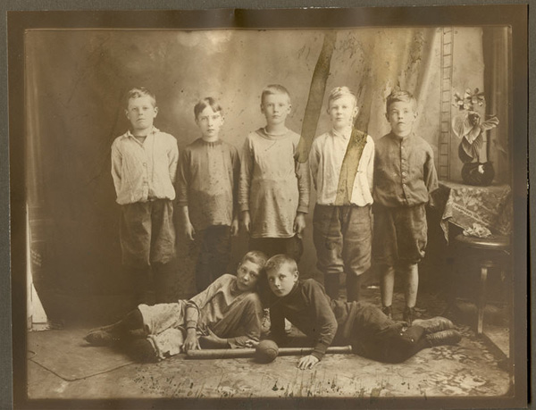 a team photo of seven boys posing with their baseball equipment.