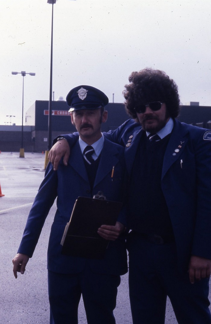 Two drivers standing with their arms around each other smiling