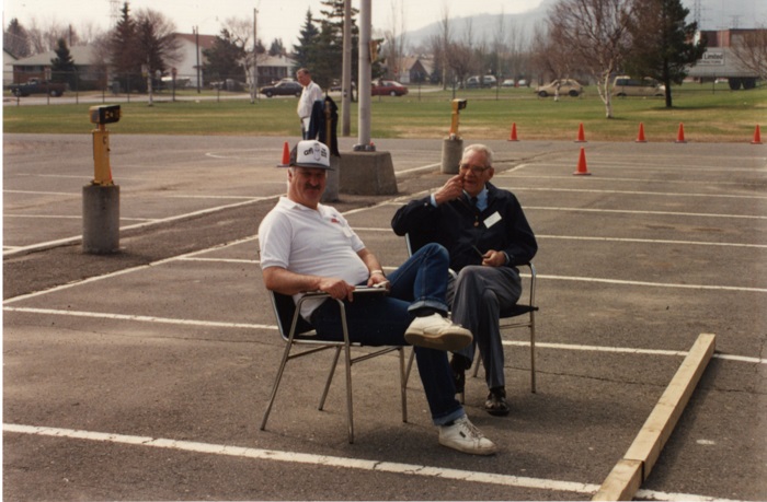 Two men sitting in lawn chairs and smiling towards the camera