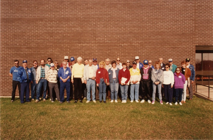 A group of people standing together in front of a brick building