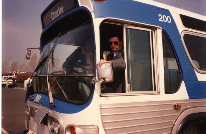 A transit driver sitting looking out the window of a bus he is driving