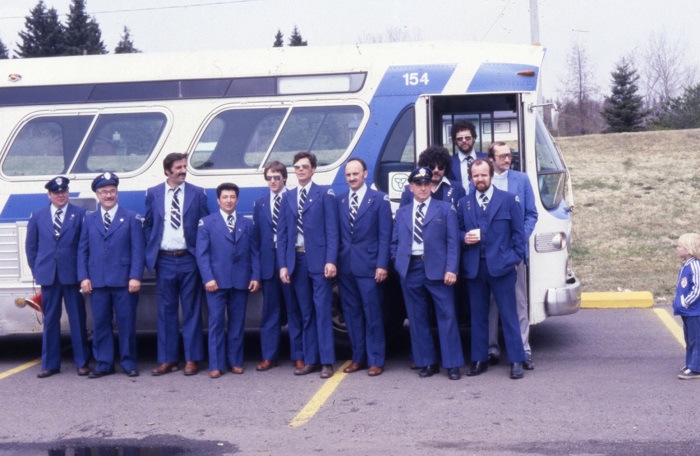 A group of transit driver standing for a photograph in front of a bus