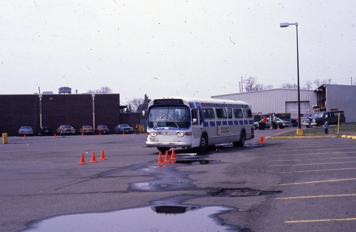 A bus driving towards a set of orange cones to navigate between them 