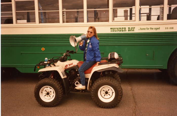 A person sitting on an all terrain vehicle with a bullhorn loud speaker