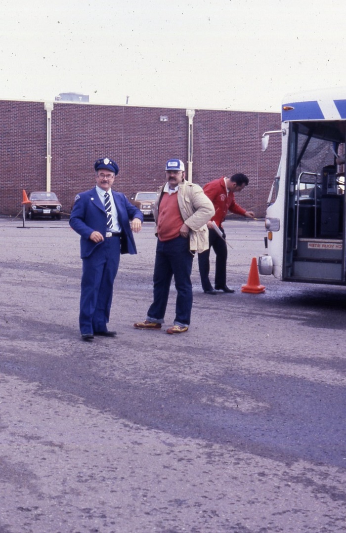 Two men standing in front of a bus 