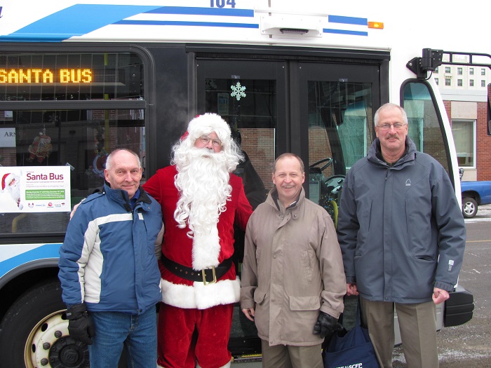 Santa with a three Thunder Bay citizen in front of the Santa Bus