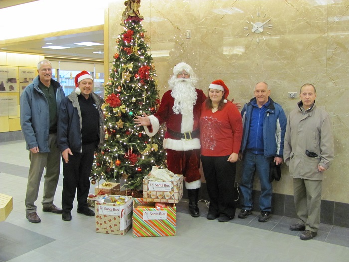 Santa and his helpers in front of the Christmas tree 