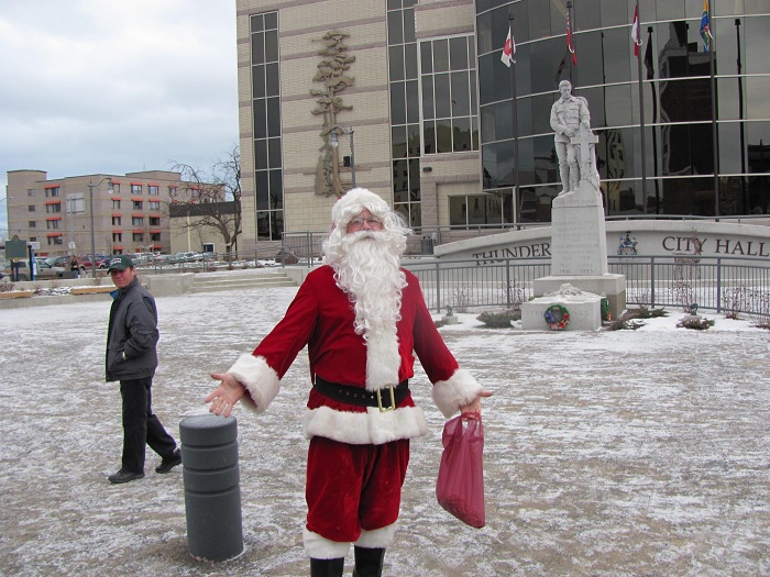 Santa outside city hall, a light dusting of snow covers the ground