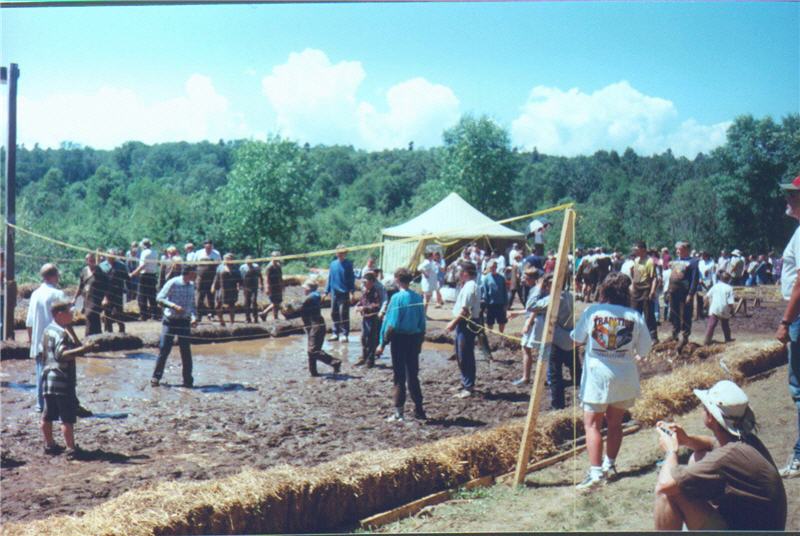A group of men and boys playing volleyball in the mud