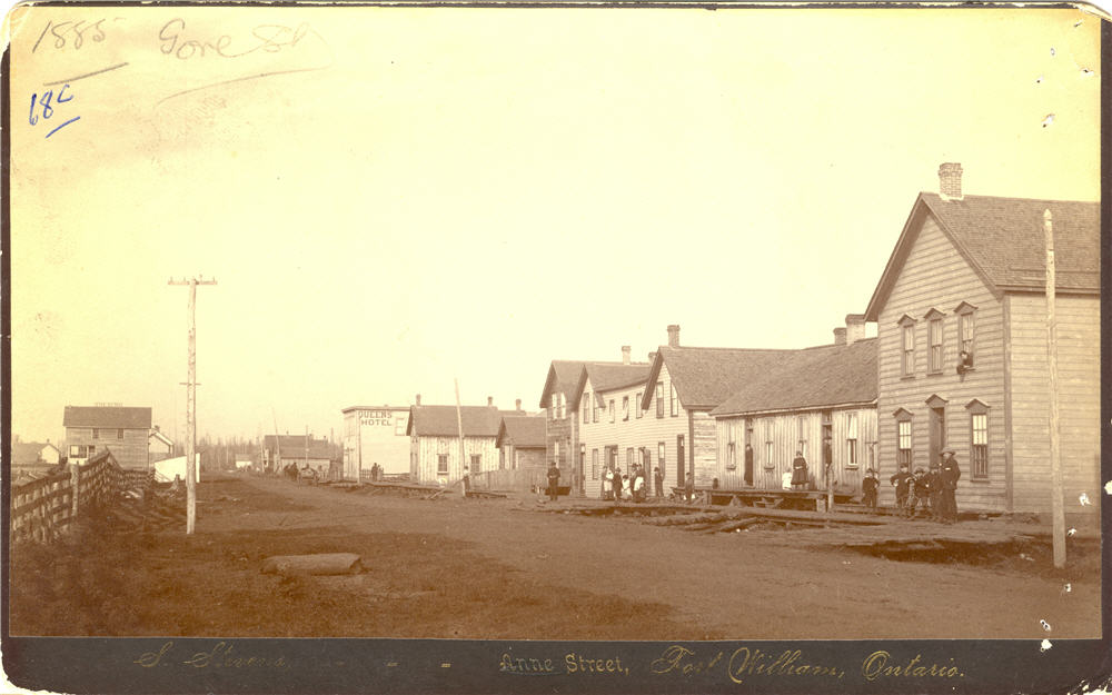 Queen's Hotel and various other buildings, unidentified individuals standing outside of buildings,