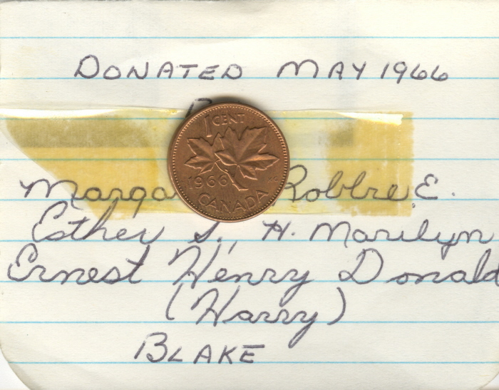 A penny taped to a piece of lined paper with writing above and below