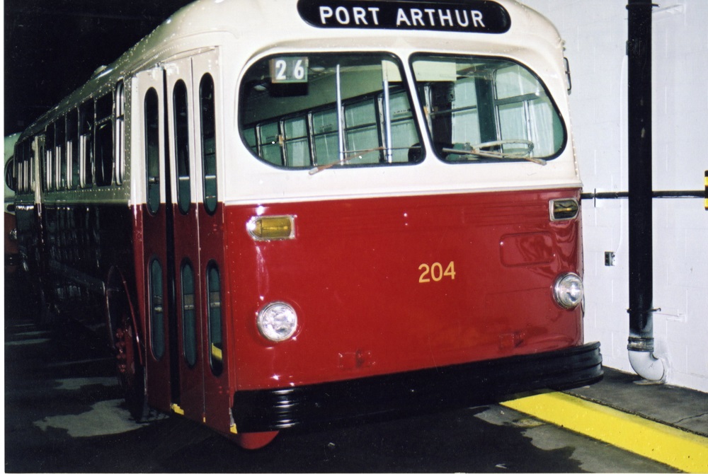 a red and white trolley bus with the words Port Arthur along the front