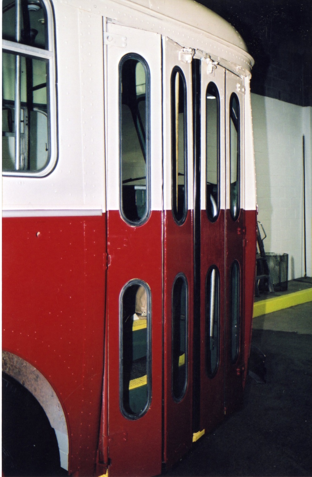 A trolley bus door coloured red and white shown closed 