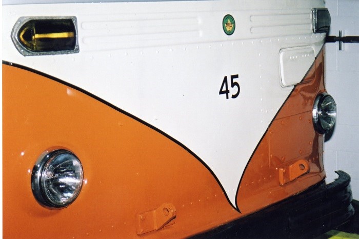 An orange and white bus with the number 45 and a green circle logo on the front