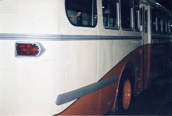 An orange and white bus from the side 