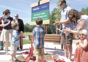 group of people unveiling plaque for Suzan Labine