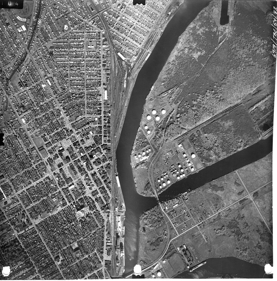 A black and white photo of the waterfront and surrounding residental area