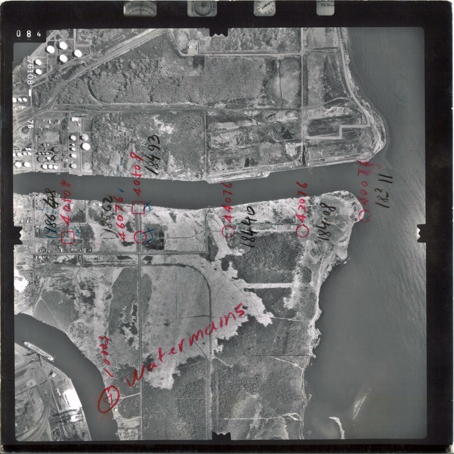 A black and white aerial photo showing the waterfront and surrounding area  
