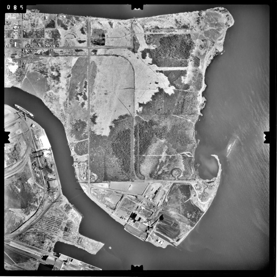 A black and white aerial photo showing the waterfront and surrounding area  