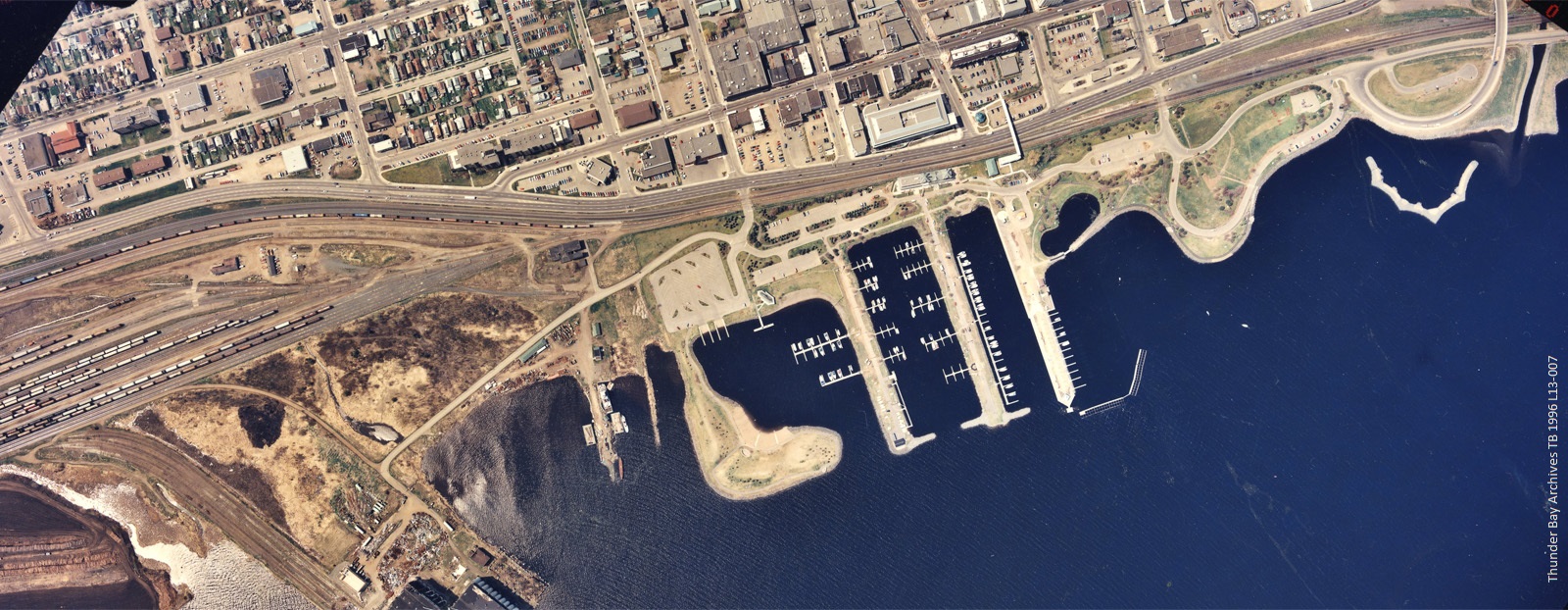 An aerial photo of a harbour, with open water and residential area behind