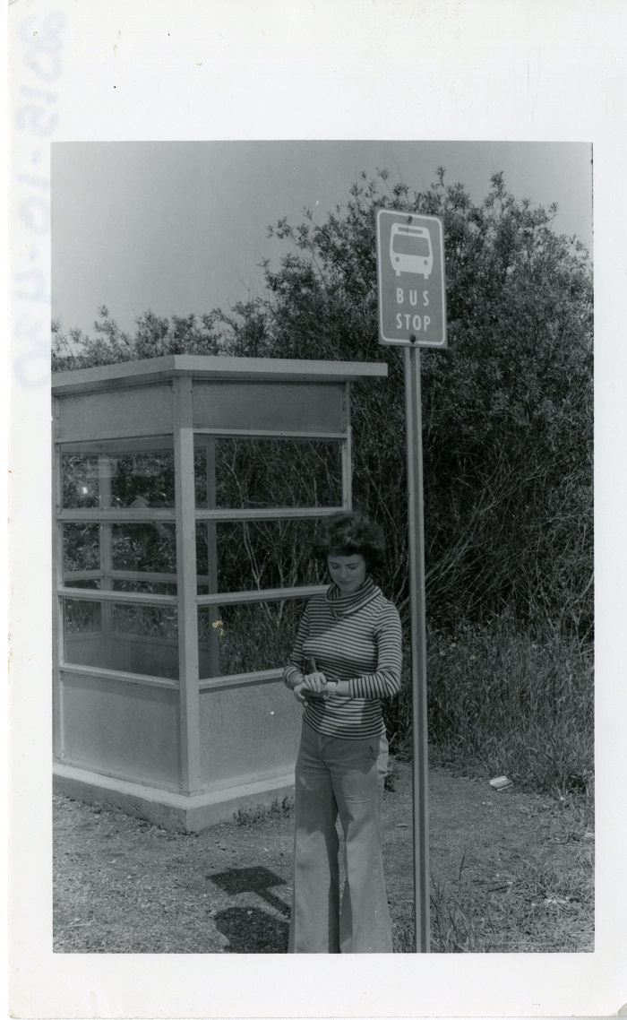 a woman at a bus stop checking her watch