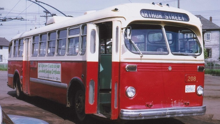 A red and white trolley with its doors open waiting for passengers