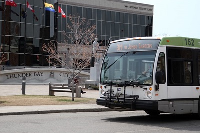 A bus sitting out front of city hall waiting for passengers